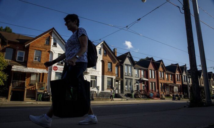 2022 年 7 月 12 日，一个人走过多伦多的一排房屋。（加拿大新闻社/Cole Burston）