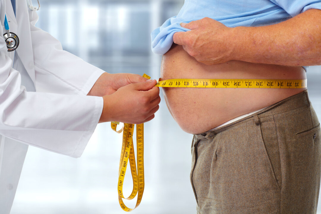 Doctor measuring obese man waist body fat. (grinny/Shutterstock)