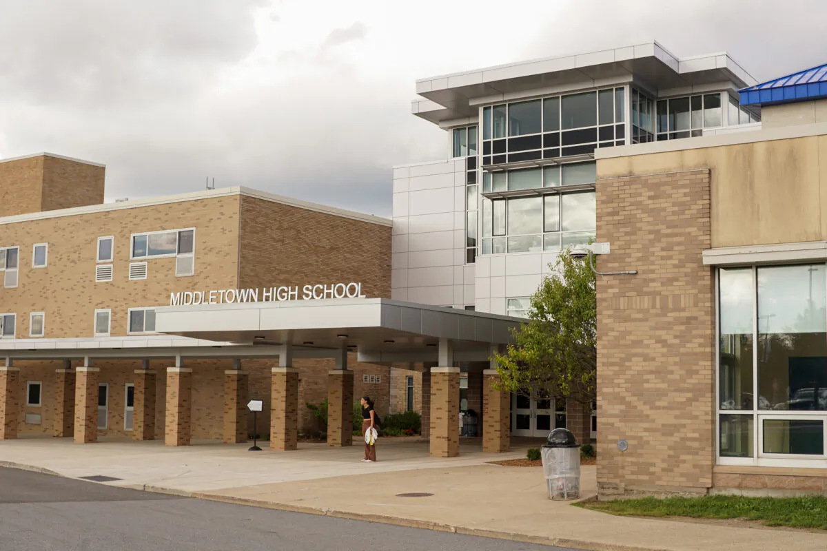 A student waits at the building entrance of Middletown High School after dismissal in Middletown, N.Y., on Sept. 20, 2022. (Cara Ding/The Epoch Times)