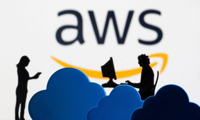 3D printed clouds and figurines in front of the AWS (Amazon Web Service) cloud service logo in a photo illustration taken on Feb. 8, 2022. (Dado Ruvic/Illustration/Reuters)