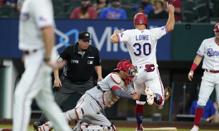 Los Angeles Angels catcher Kurt Suzuki, left, tags out Texas Rangers' Nathaniel Lowe (30) in the sixth inning of a baseball game in Arlington, Texas, Sept. 22, 2022. (Tony Gutierrez/AP Photo)