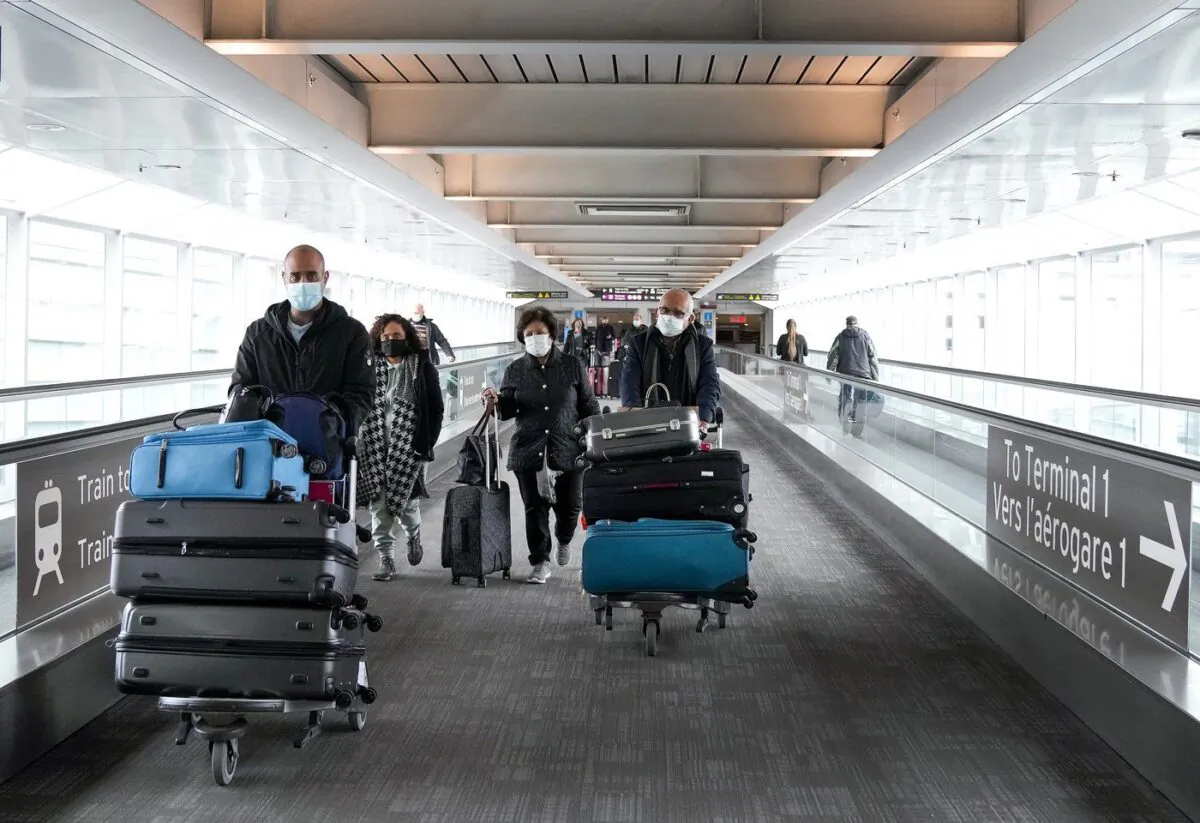 People travel at Pearson International Airport, in Toronto, Dec. 3, 2021. (The Canadian Press/Nathan Denette)