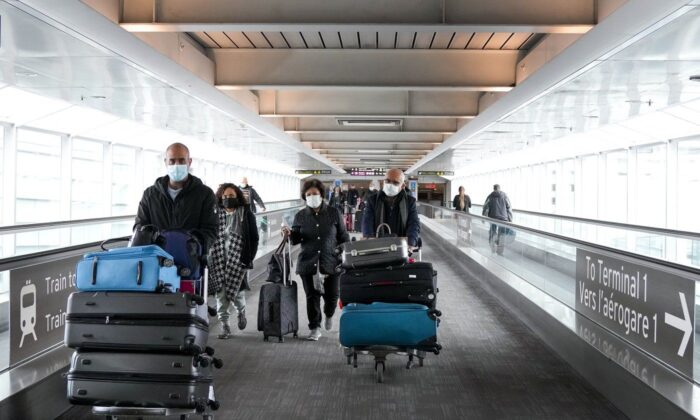 People travel at Pearson International Airport, in Toronto, Dec. 3, 2021. (The Canadian Press/Nathan Denette)
