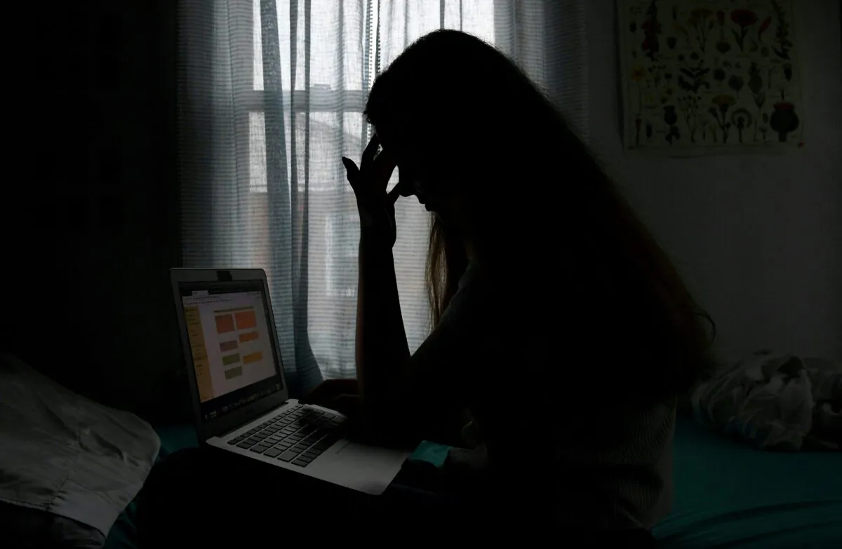 In this photo illustration, a teenager poses with a laptop in Arlington, Va., on June 11, 2021. (Olivier Douliery/AFP via Getty Images)