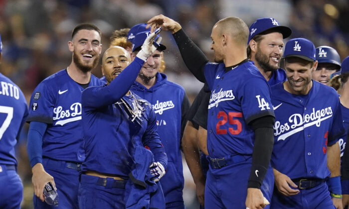 Los Angeles Dodgers' Mookie Betts, center, is greeted by Trayce Thompson (25) and other teammates after he hit a walk-off single to win a baseball game 3–2 against the Arizona Diamondbacks in Los Angeles, on Sept. 22, 2022. (Ashley Landis/AP Photo)