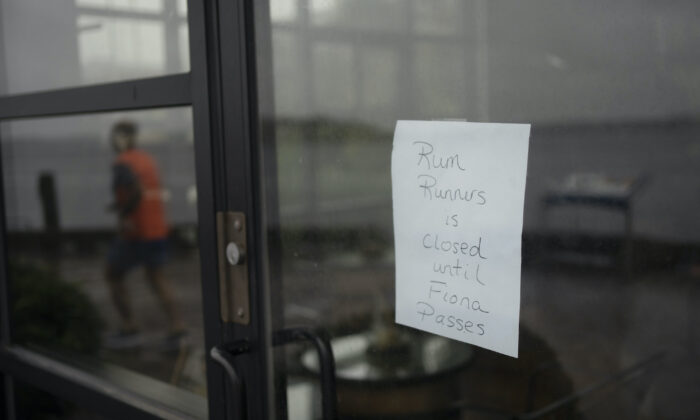 A sign in the window of a storefront on the Halifax waterfront is seen ahead of Hurricane Fiona making landfall in Halifax, on Sept. 23, 2022. (The Canadian Press/Darren Calabrese)