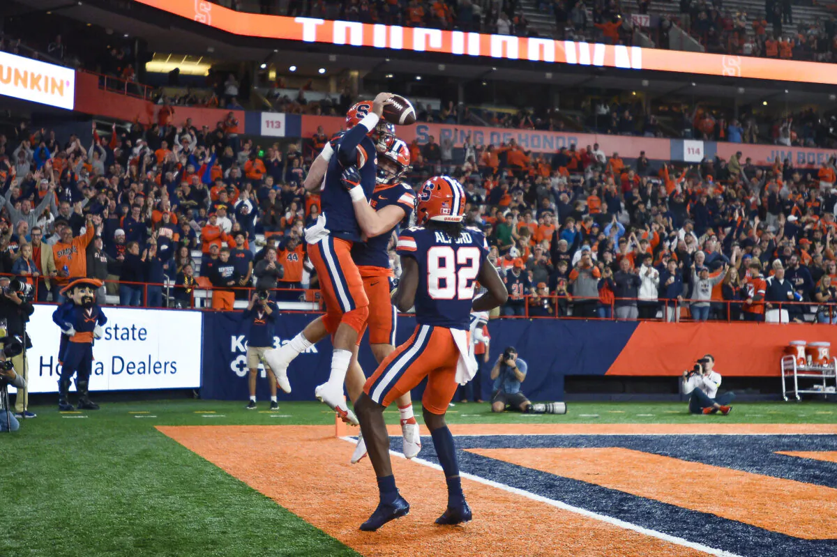 Syracuse quarterback Garrett Shrader (6) celebrates with tight end Maximilian Mang and wide receiver Damien Alford (82) after scoring against Virginia during the first half of an NCAA football game in Syracuse, N.Y., Sept. 23, 2022. (Adrian Kraus/AP Photo)