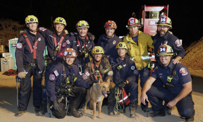 Firefighters pose with a Cesar a blind dog that was rescued from a hold in Pasadena, Calif., on Sept. 20, 2022. (Pasadena Fire Department via AP)