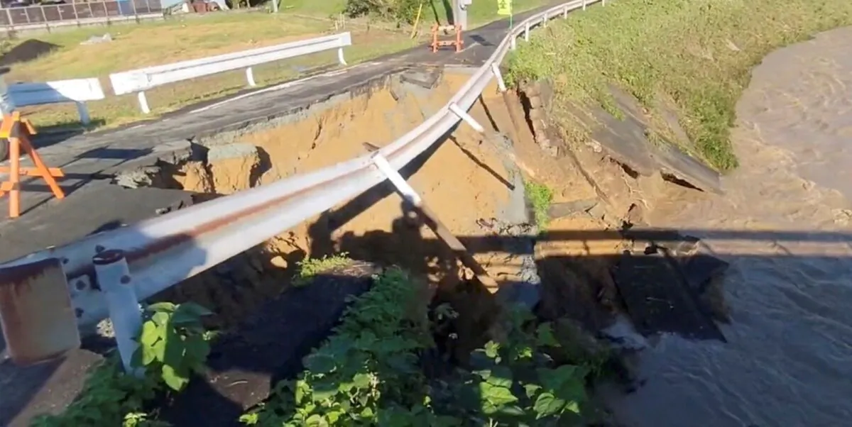 A part of a street collapses into a river in the aftermath of a heavy storm, in Fukuroi, Shizuoka Prefercture, Japan, on Sept. 24, 2022, in this still image obtained from a social media video. (Twitter @tetsuya47sbs via Reuters)