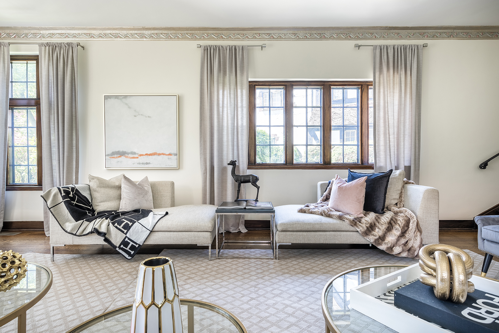 A neutral foundation of cream and gray is accented by mauve and black accents including artwork.