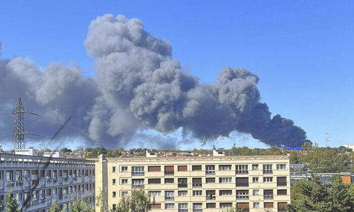 Dym unosi się z pożaru magazynu na targu produktów na południowych przedmieściach Paryża 25 września 2022 r. (Martin Rouger przez AP)