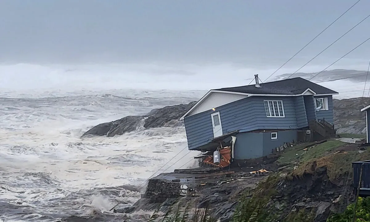 A home fights against high winds caused by post Tropical Storm Fiona in Port aux Basques, Newfoundland and Labrador, Canada, on Sept. 24, 2022. (Rene Roy/Wreckhouse Press via AP)