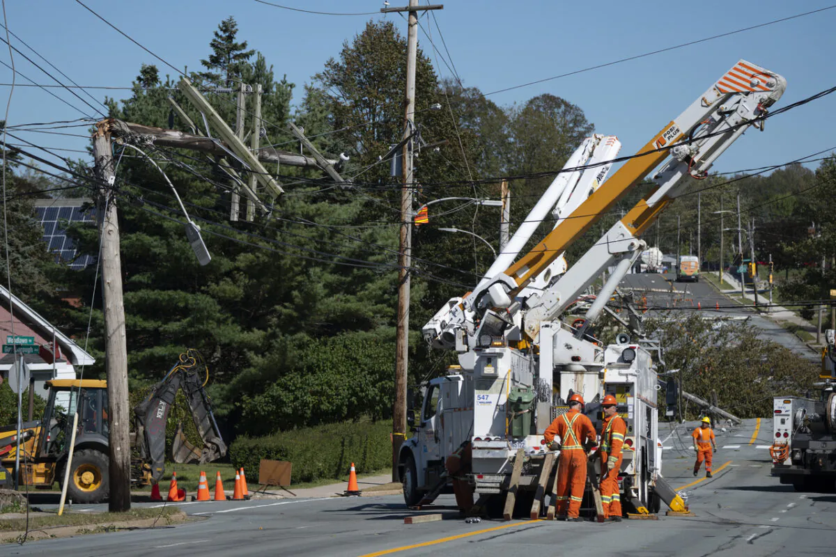Workers assess downed power poles caused by post-tropical storm Fiona in Dartmouth, N.S., on Sept. 25, 2022. (The Canadian Press/Darren Calabrese)