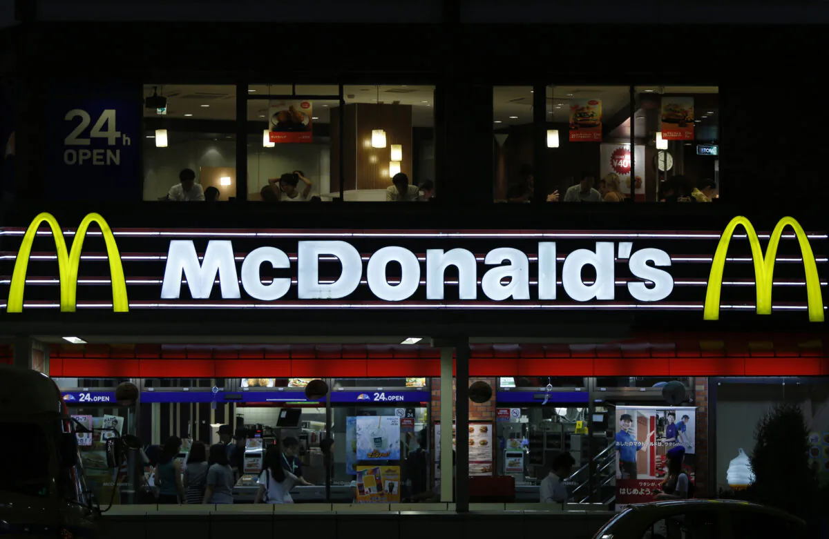 Customers are seen through the windows of a McDonald's store (top) in Tokyo, while others stand in line in front of cash registers, July 22, 2014. (Yuya Shino/Reuters)