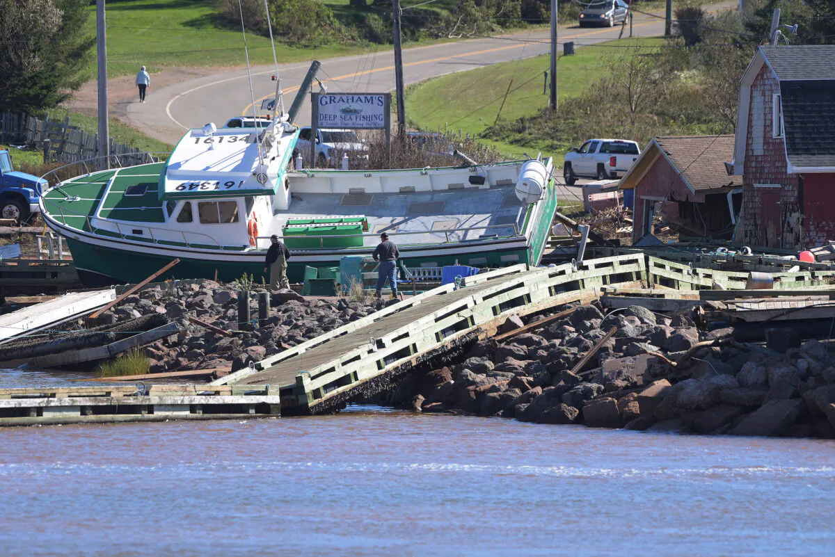 A lobster boat grounded on the rocks at the wharf in Stanley Bridge, P.E.I. on Sunday September 25, 2022. After hammering Atlantic Canada, post-tropical storm Fiona has moved inland in southeastern Quebec, with Environment Canada saying the storm will continue to weaken as it tracks across southeastern Labrador and over the Labrador Sea. (THE CANADIAN PRESS/Brian McInnis)