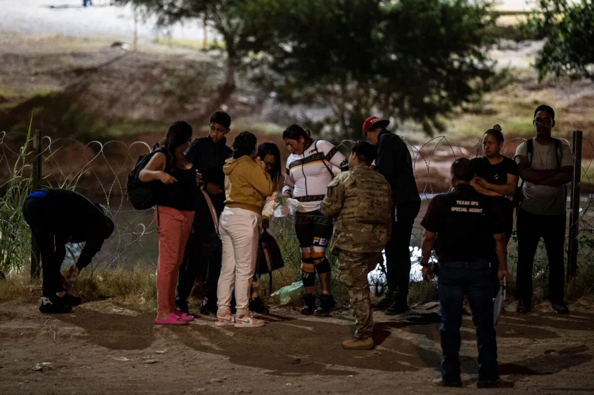 Illegal immigrants are apprehended by U.S. Border Patrol and National Guard troops in Eagle Pass, Texas, on June 30, 2022. (Chandan Khanna/AFP via Getty Images)