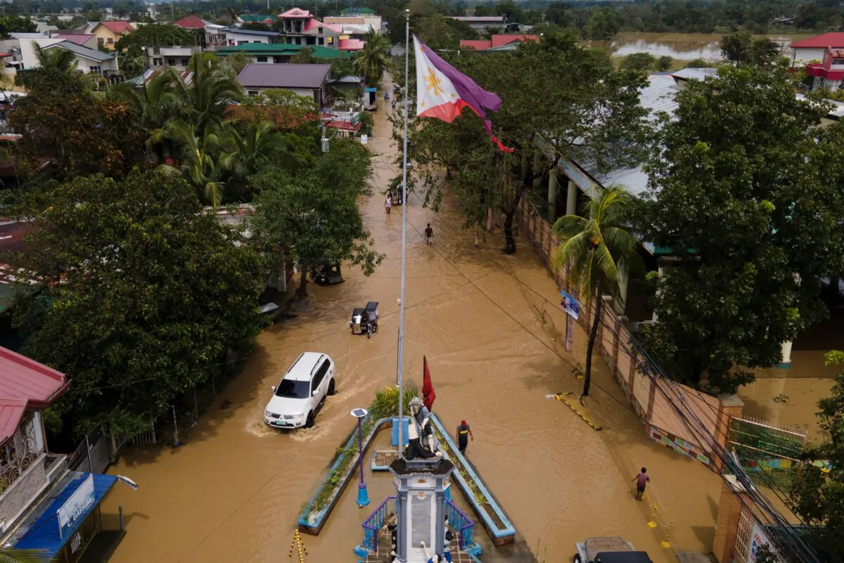 Residents pass by a flooded road from Typhoon Noru in San Miguel town, Bulacan Province, Philippines, on Sept. 26, 2022. (Aaron Favila/AP Photo)