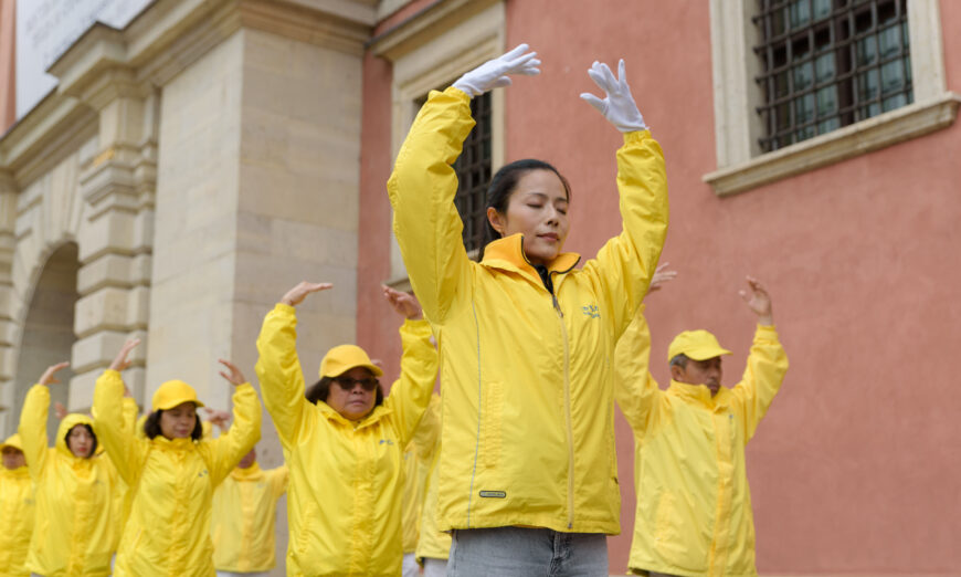 Falun Dafa practitioners meditate after a march through the center of Warsaw, Poland, on Sept. 9, 2022. (Mihut Savu/The Epoch Times)