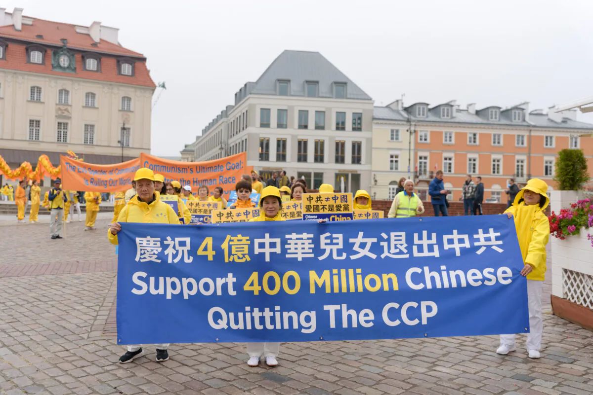 Falun Dafa practitioners carry a banner celebrating 400 million Chinese people who have withdrawed from the CCP as part of the Tuidang movement in China, during a march through the center of Warsaw, Poland, on Sept. 9, 2022. (Mihut Savu/The Epoch Times)