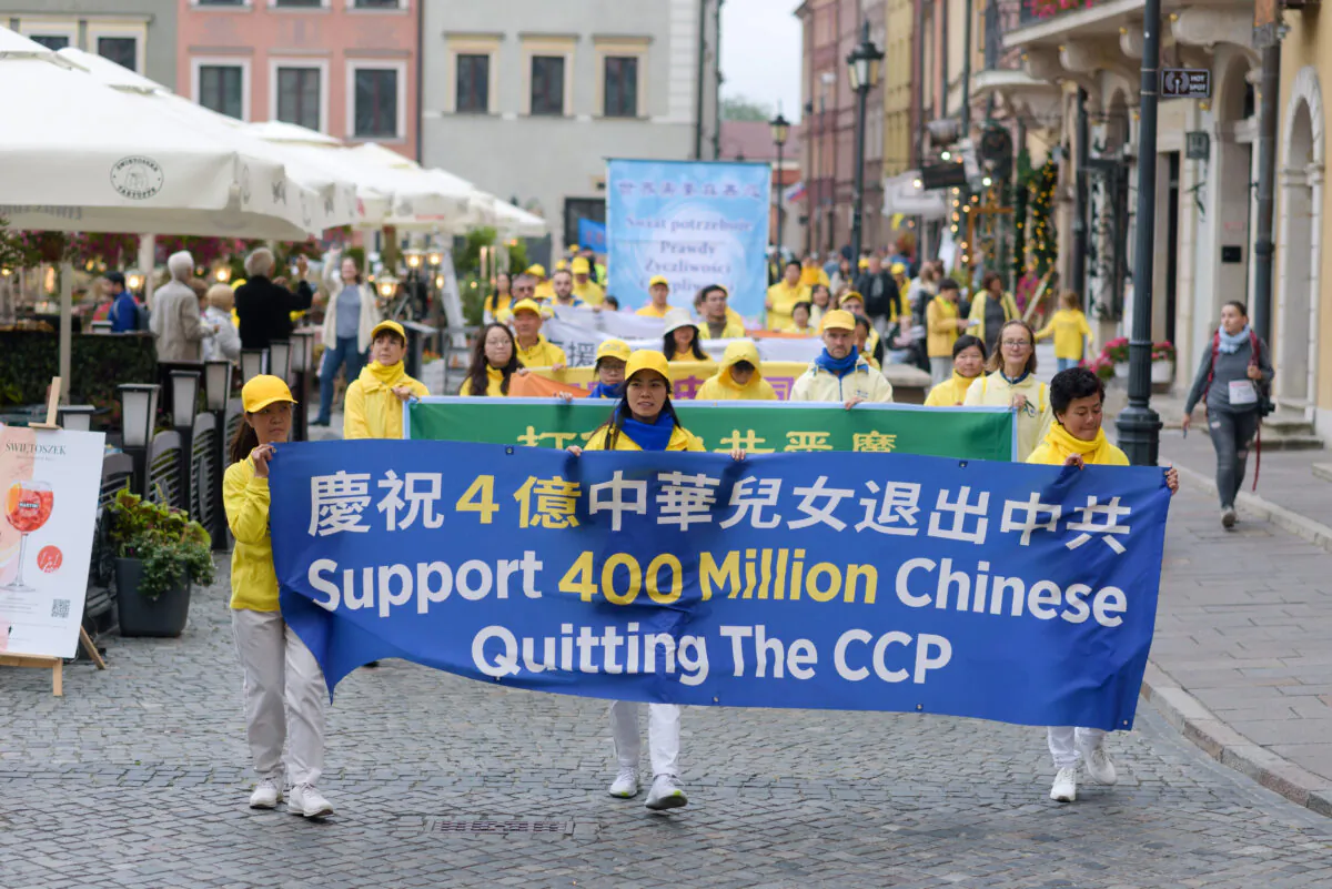 Falun Dafa practitioners carry a banner celebrating 400 million Chinese people who have withdrawn from the CCP as part of the Tuidang movement in China, during a march through the center of Warsaw, Poland, on Sept. 9, 2022. (Mihut Savu/The Epoch Times)