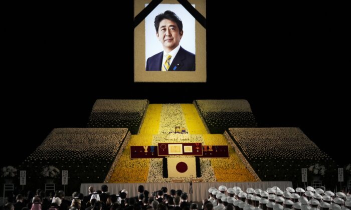 2022 年 9 月 27 日，日本前首相安倍晋三的肖像在东京举行的国葬期间悬挂在舞台上。（Franck Robichon/Pool Photo via AP）