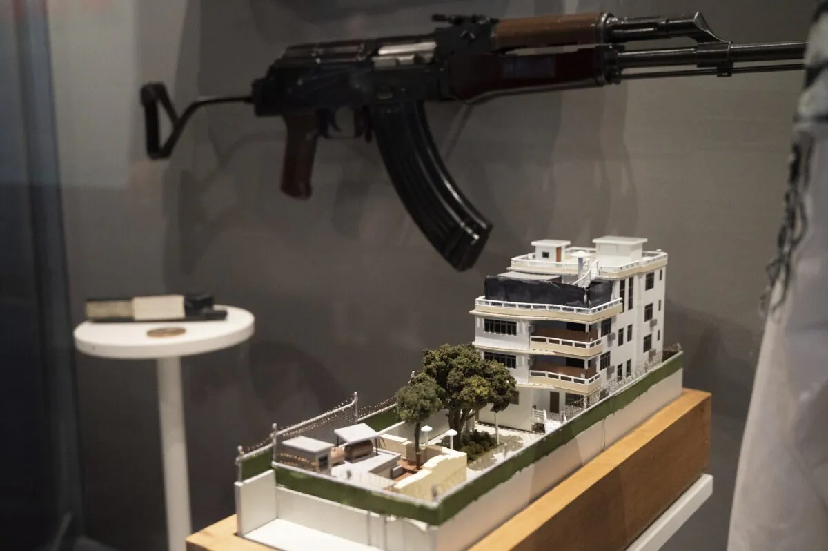 A model of the house where a precision counterterrorism operation killed al-Qaeda's leader Ayman al-Zawahri is displayed below a rifle used by Michael Spann, the first American killed in Afghanistan, in the refurbished museum at the Central Intelligence Agency headquarters building in Langley, Va., on Sept. 24, 2022. (Kevin Wolf/AP Photo)