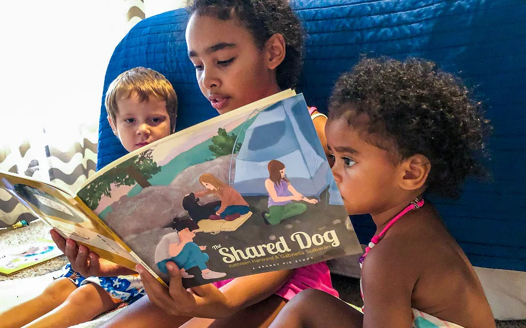 Three children read "The Shared Dog," Brandy Pie Book Company's first publication. (Courtesy of Brandy Pie Book Company)
