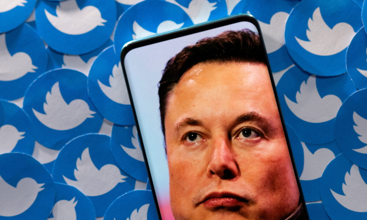 智能手机上的 Elon Musk 图片和打印的 Twitter 徽标