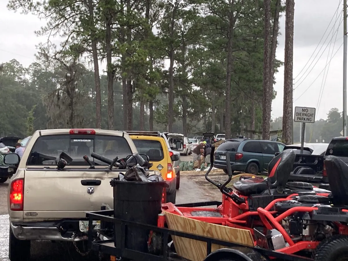 As the first rain from Hurricane Ian begins to fall in North Central Florida on Sept. 28, Alachua County residents clog the roadway leading to do-it-yourself, sandbag stations to fill government-provided bags using shovels brought from home. (Nanette Holt/The Epoch Times)