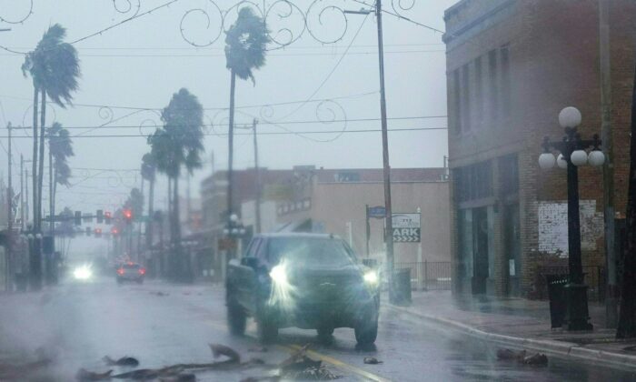 A pickup truck drives around fallen debris and palm trees in the Ybor City neighborhood ahead of Hurricane Ian making landfall in Tampa, Fla., on Sept. 28, 2022. (Bryan R. Smith/AFP via Getty Images)