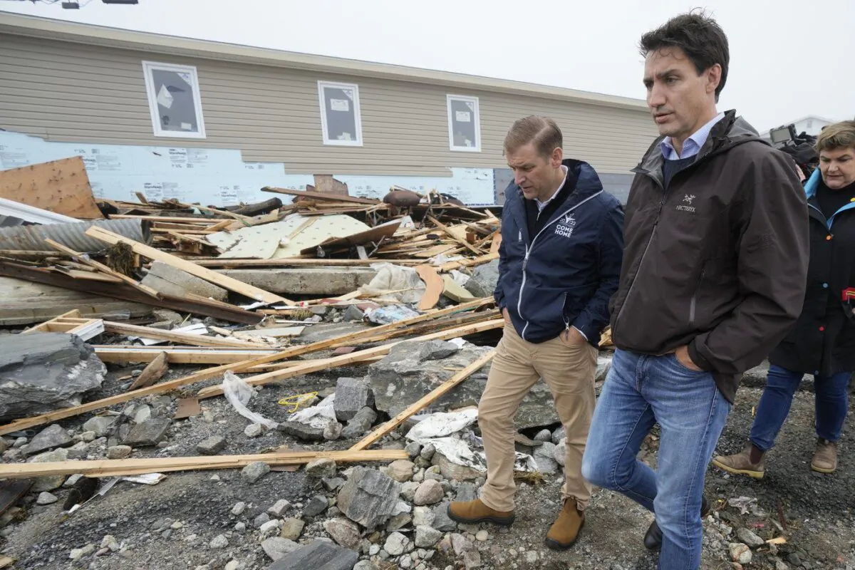 Prime Minister Justin Trudeau, right, and Newfoundland and Labrador Premier Andrew Furey tour the damage cause by post-tropical storm Fiona in Port aux Basques, N.L. on Sept. 28, 2022. (The Canadian Press/Frank Gunn)