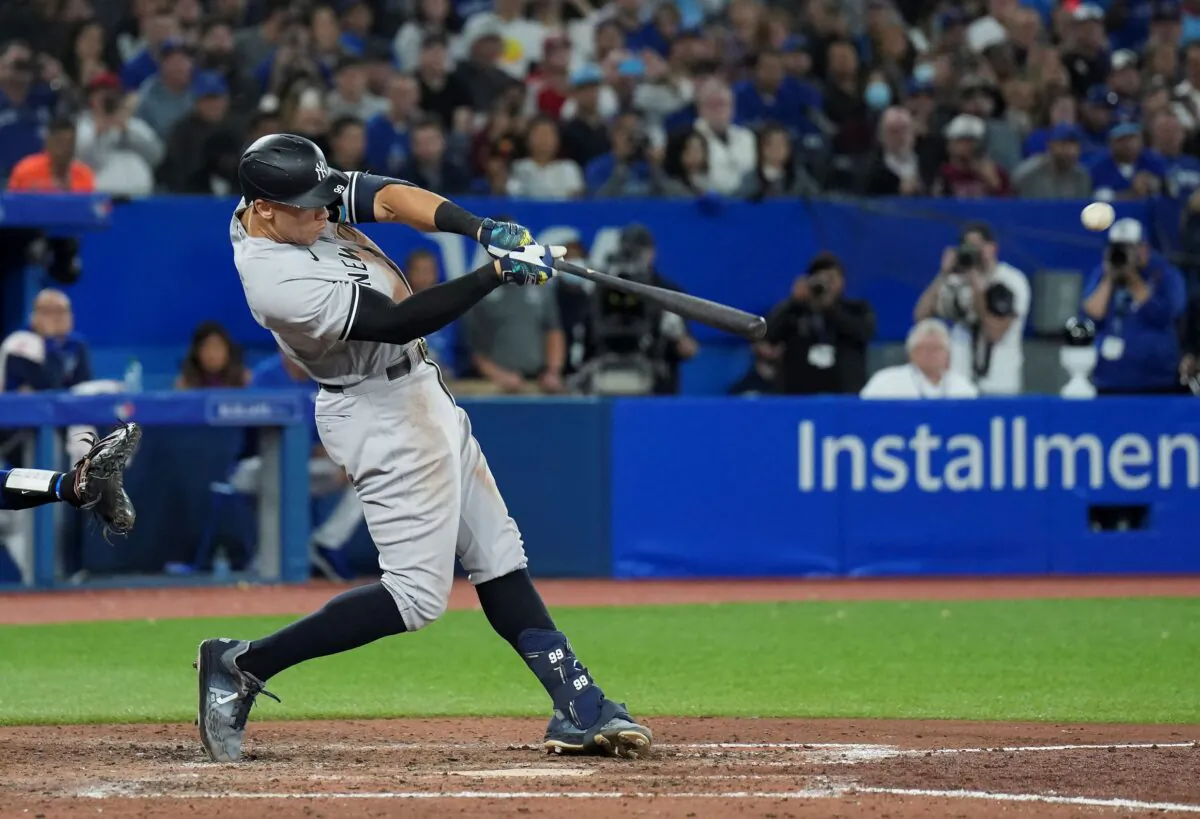 New York Yankees' Aaron Judge hits a two-run home run, his 61st homer of the season, during the seventh inning of the team's baseball game against the Toronto Blue Jays in Toronto on Sept. 28, 2022. (Nathan Denette/The Canadian Press via AP)