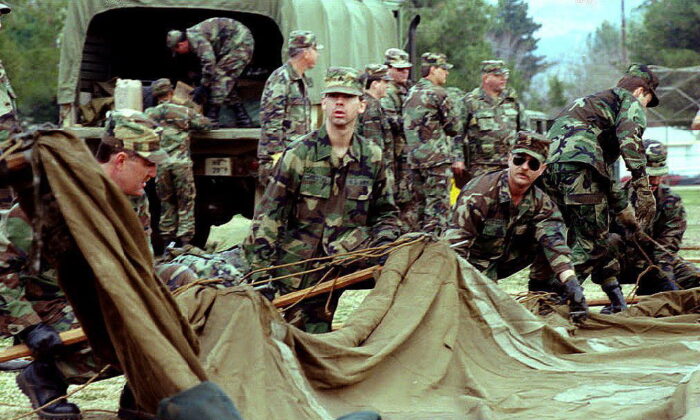 1994 年 1 月 22 日，加州国民警卫队的部队在加利福尼亚州北岭的 Winnetka 娱乐中心为地震灾民搭建帐篷。国民警卫队正在各个公园建造帐篷城，以容纳数千名害怕的人1994 年 1 月 17 日北岭地震，返回家园或其家园遭到破坏。（Bob Pearson/AFP via Getty Images）