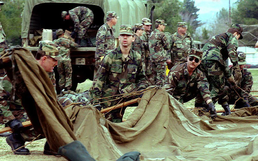 Troops of the California National Guard erect a tent to house earthquake victims at the Winnetka Recreation Center in Northridge, Calif., on Jan. 22, 1994. The National Guard is building tent cities at various public parks to house thousands of people who are afraid to return home or whose homes were damaged by the Northridge earthquake on Jan. 17, 1994. (Bob Pearson/AFP via Getty Images)