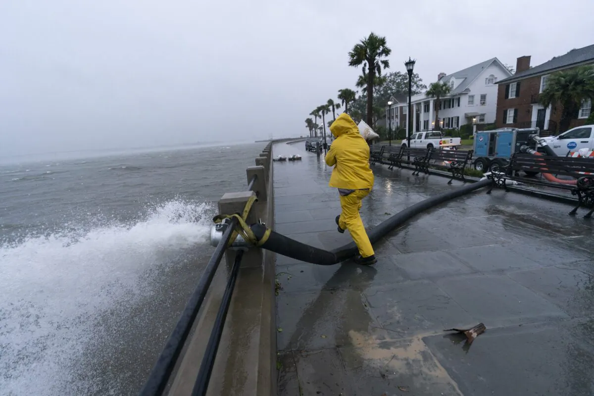 A worker moves a sandbag after a pump was placed to remove water from the Battery as the effects from Hurricane Ian are felt, in Charleston, S.C., on Sept. 30, 2022. (Alex Brandon/AP Photo)