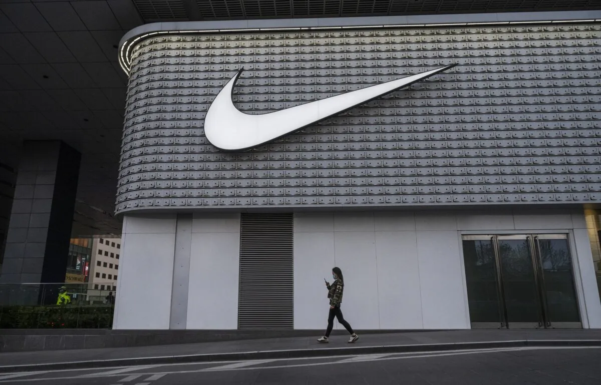 A woman walks outside a Nike store at a shopping area in Beijing on April 8, 2021. (Kevin Frayer/Getty Images)