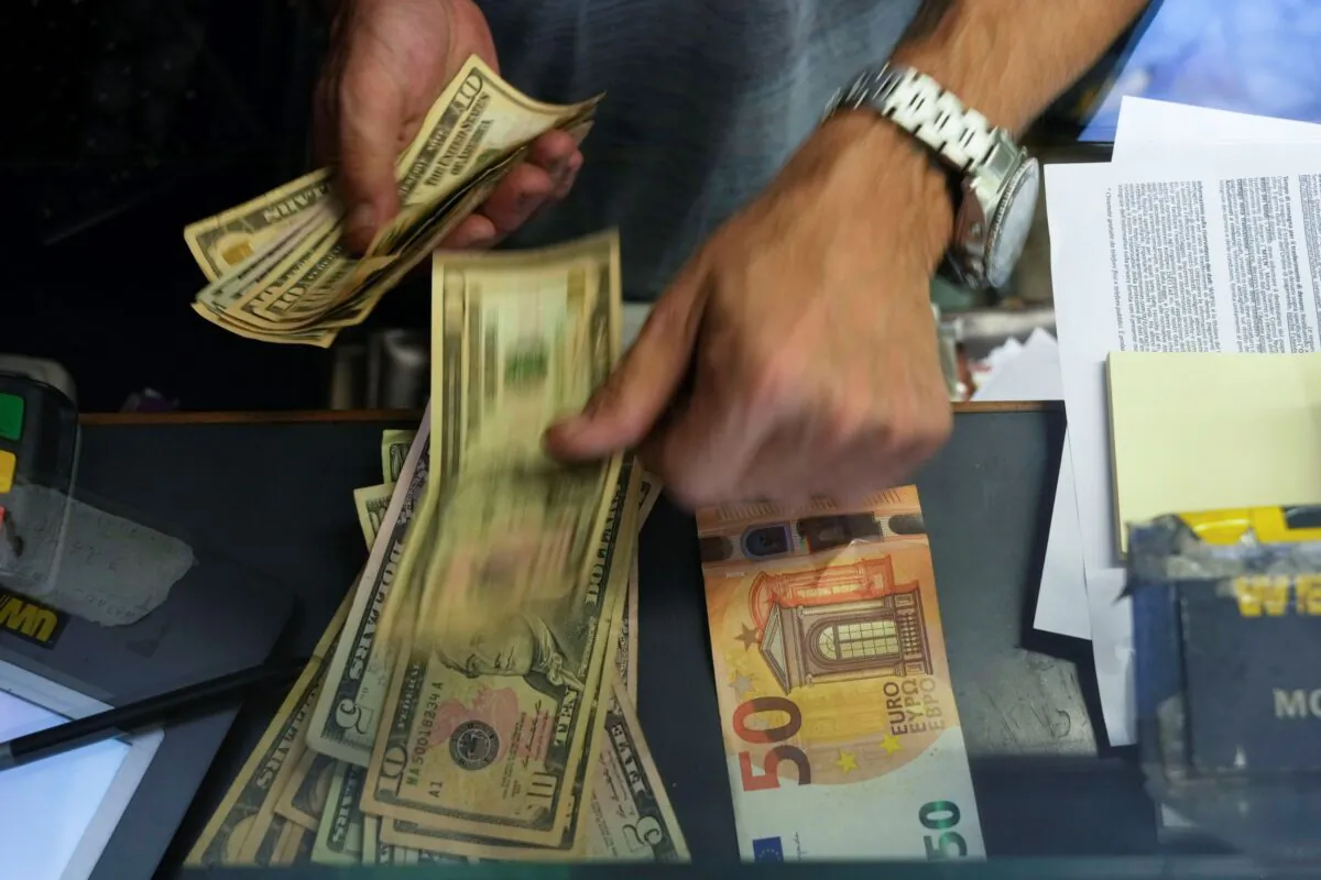 A cashier exchanges a 50 Euro banknote for U.S. dollars at an exchange counter in Rome, Italy, on July 13, 2022. (Gregorio Borgia/AP Photo)