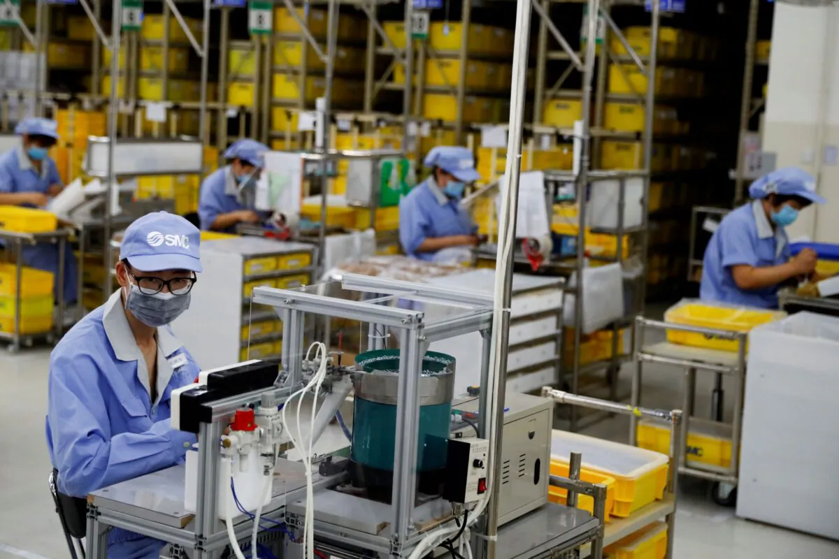 Employees work at a factory of the component maker SMC in Beijing on May 13, 2020. (Thomas Peter/Reuters)