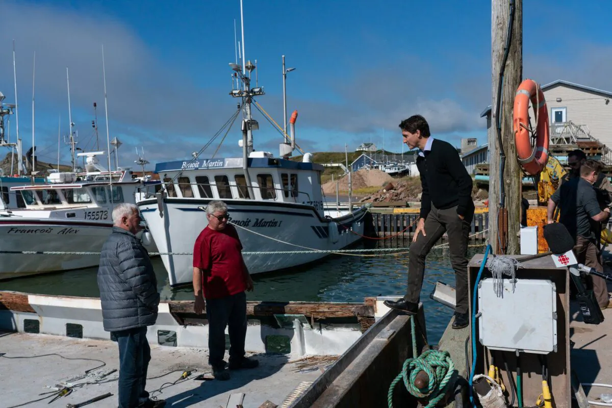 Prime Minister Justin Trudeau discusses post-tropical storm Fiona with local fishermen at Pointe-Basse wharf in Havre-aux-Maisons, Que., Sept. 29, 2022. (The Canadian Press/Nigel Quinn)