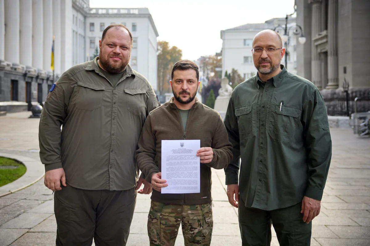 Ukraine's President Volodymyr Zelenskyy, Prime Minister Denys Shmyhal, and Parliament Speaker Ruslan Stefanchuk pose with a request for fast-track membership in the NATO military alliance in Kyiv, Ukraine, on Sept. 30, 2022. (Ukrainian Presidential Press Service/Handout via Reuters)
