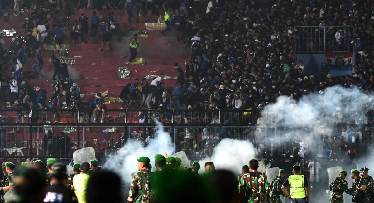 Security personnel (lower) on the pitch at Kanjuruhan stadium in Malang, East Java, Indonesia, on Oct. 1, 2022. (STR/AFP via Getty Images)