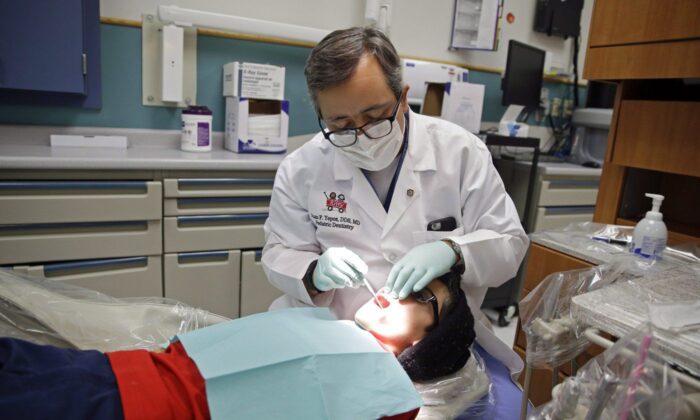 A dentist at Riley Children's Hospital Pediatric Dentistry checks Justin Perez's teeth on January 22, 2016.  (The Canadian Press/Michael Conroy)