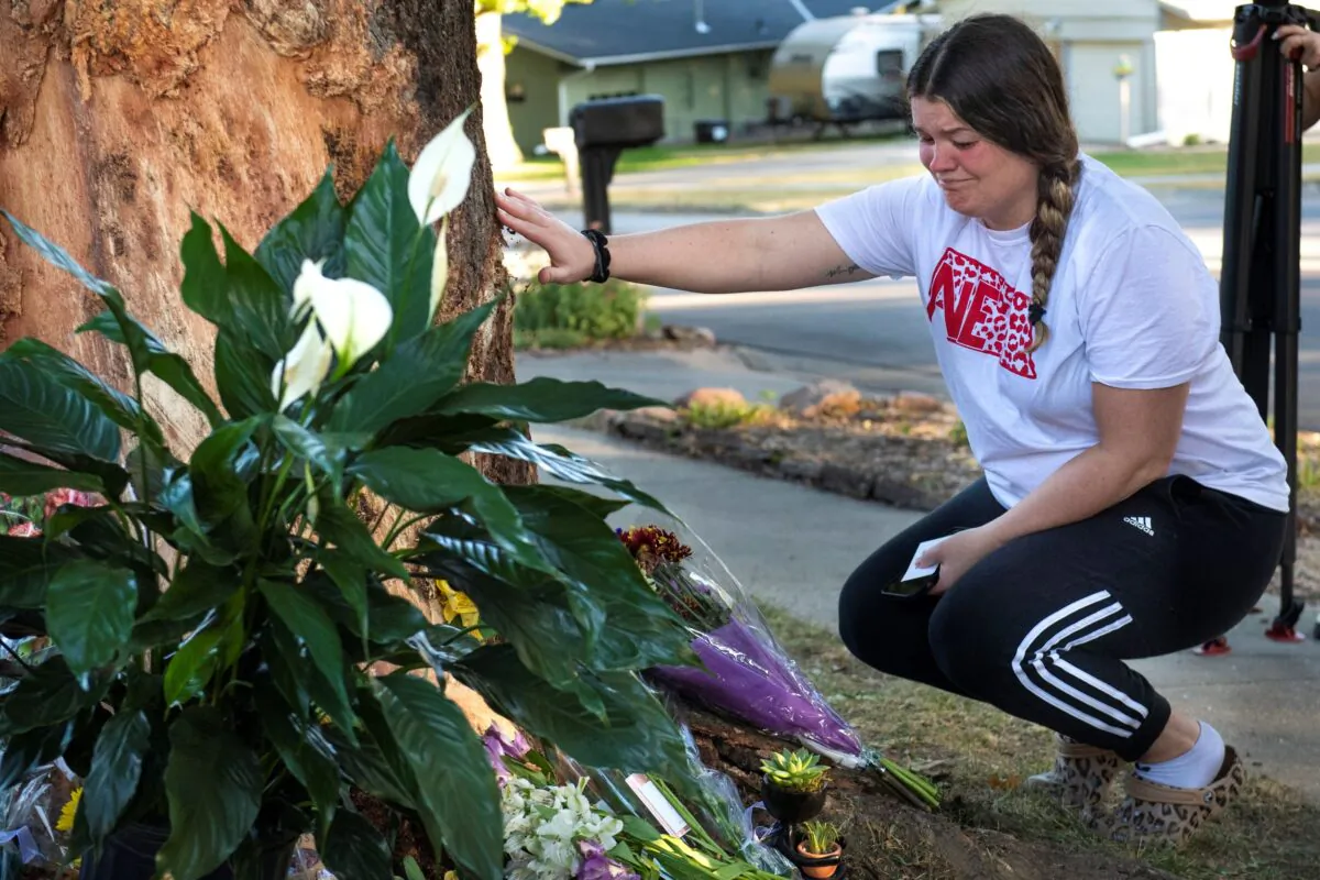Kayla Kelly grieves as mourners gather and lay flowers and gifts at the site of a deadly car crash during an impromptu memorial service in Lincoln, Neb., on Oct. 2, 2022. (Kenneth Ferriera/Lincoln Journal Star via AP)