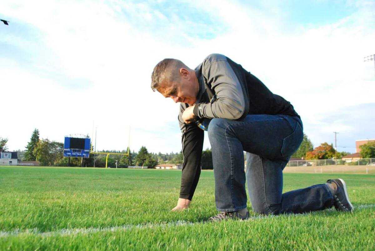 Coach Joe Kennedy praying on a football field. (Courtesy of First Liberty Institute)