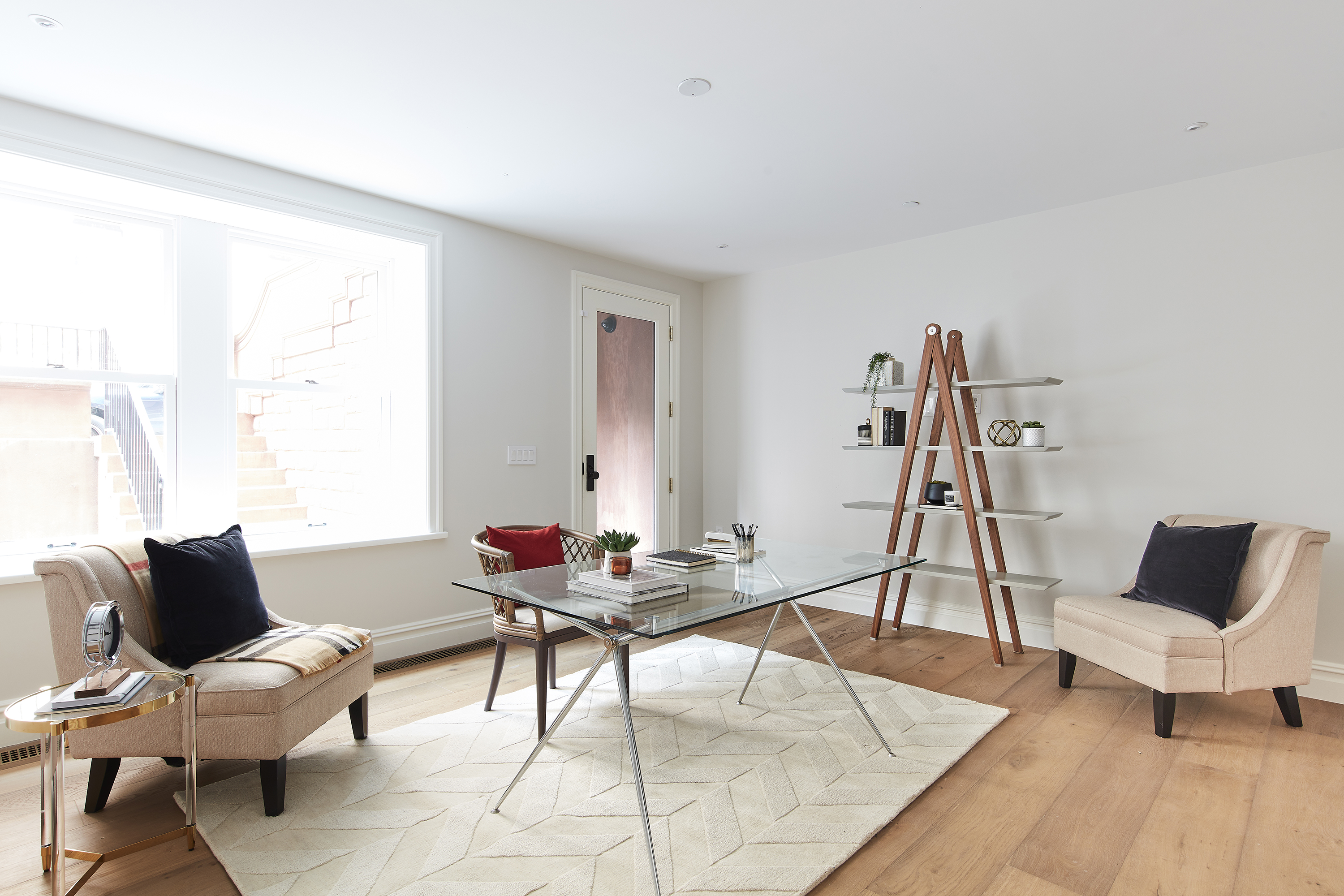 A below grade space is lightened through the use of transparent surfaces and light fabrics and textiles. 