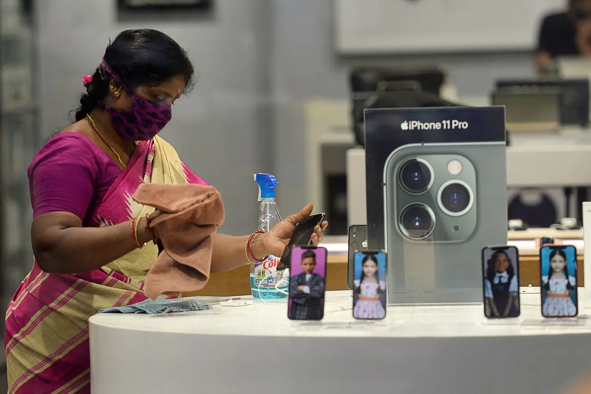 A worker sanitises an Apple store inside a shopping mall reopened after the government eased a nationwide lockdown imposed as a preventive measure against the Covid-19 coronavirus, in Chennai, India, on Sept. 1, 2020. (Arun Sankar/AFP via Getty Images)