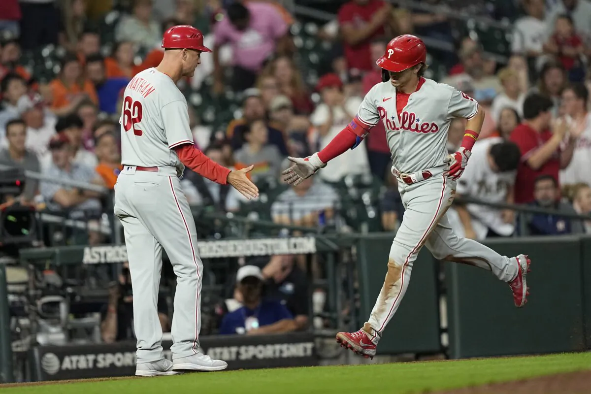 Philadelphia Phillies' Bryson Stott (5) celebrates with third base coach Dusty Wathan (62) after hitting a home run against the Houston Astros during the eighth inning of a baseball game in Houston on Oct. 3, 2022. (David J. Phillip/AP Photo)