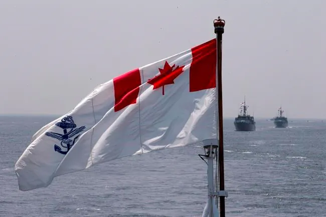 The Royal Canadian Navy Ensign flies on the HMCS Kingston and HMCS Moncton sail behind during the Parade of Ships entering the New York Harbor, May 25, 2016. (The Canadian Press/Mary Altaffer)