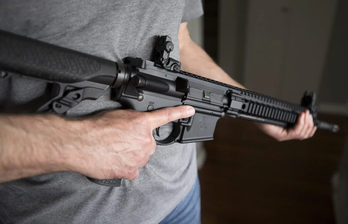 A restricted gun licence holder holds a AR-15 at his home in Langley, B.C., on May 1, 2020.  (The Canadian Press/Jonathan Hayward)