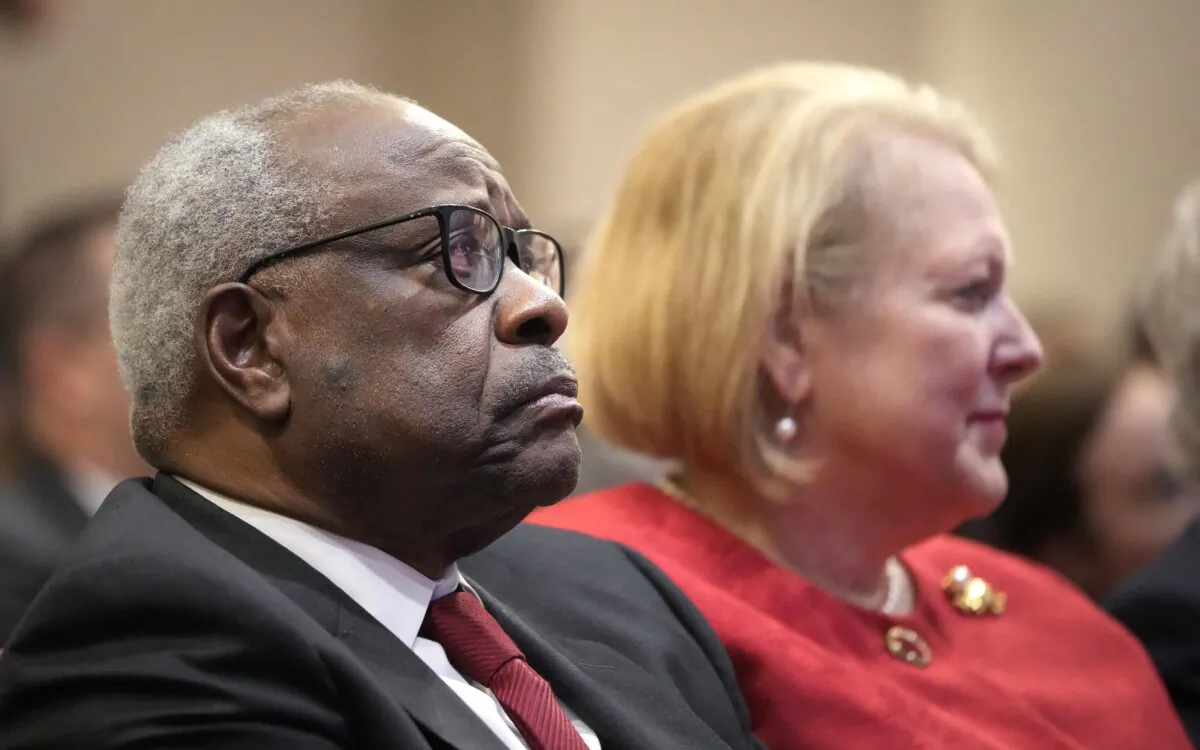 Associate Supreme Court Justice Clarence Thomas sits with his wife and conservative activist Virginia Thomas while he waits to speak at the Heritage Foundation in Washington, D.C., on Oct. 21, 2021. (Drew Angerer/Getty Images)